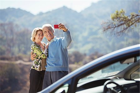 Senior couple taking self-portrait with cell phone outside car Photographie de stock - Premium Libres de Droits, Code: 6113-07565001