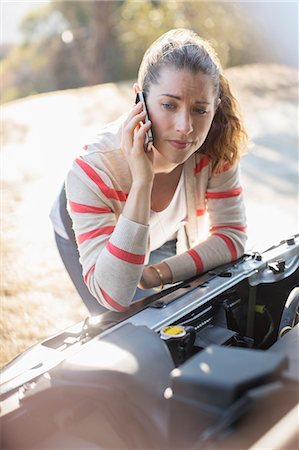 people with broken down cars - Frustrated woman talking on cell phone and looking at car engine Stock Photo - Premium Royalty-Free, Code: 6113-07565147
