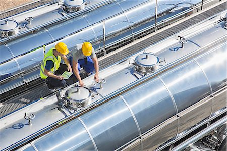 simsearch:6113-07565437,k - Workers on platform above stainless steel milk tanker Foto de stock - Sin royalties Premium, Código: 6113-07565351