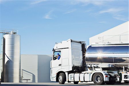 Truck driver parking stainless steel milk tanker outside silage storage tower Photographie de stock - Premium Libres de Droits, Code: 6113-07565356