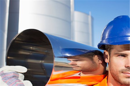 storage tank white - Close up of worker carrying stainless steel tube Stock Photo - Premium Royalty-Free, Code: 6113-07565393