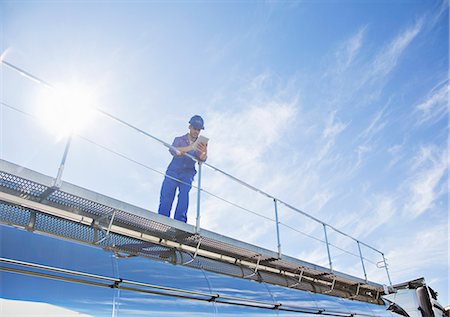 Worker with digital tablet standing on platform above stainless steel milk tanker Photographie de stock - Premium Libres de Droits, Code: 6113-07565334