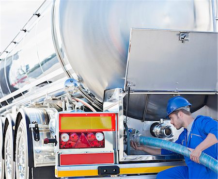 simsearch:6113-07565355,k - Worker attaching hose to back of stainless steel milk tanker Stock Photo - Premium Royalty-Free, Code: 6113-07565440