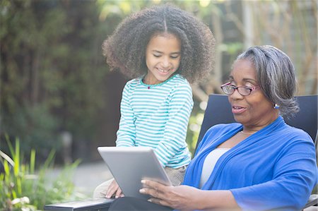 domestic - Grandmother and granddaughter using digital tablet outdoors Stock Photo - Premium Royalty-Free, Code: 6113-07565463