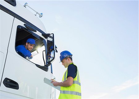 Worker with clipboard talking to truck driver Photographie de stock - Premium Libres de Droits, Code: 6113-07565425