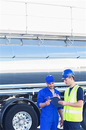 Workers with clipboard talking next to stainless steel milk tanker Stock Photo - Premium Royalty-Free, Code: 6113-07565426