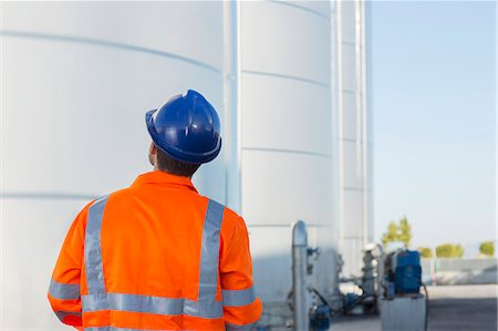 fuel storage tank - Worker looking up at silage storage towers Stock Photo - Premium Royalty-Free, Code: 6113-07565429