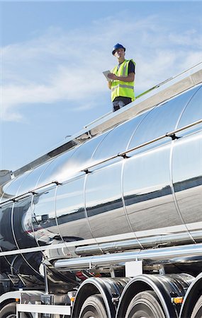 Worker using digital tablet on platform above stainless steel milk tanker Photographie de stock - Premium Libres de Droits, Code: 6113-07565439