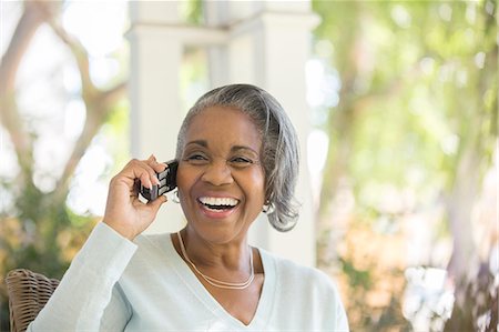 senior smiling happy alone not eye contact - Enthusiastic senior woman talking on telephone on porch Stock Photo - Premium Royalty-Free, Code: 6113-07565562