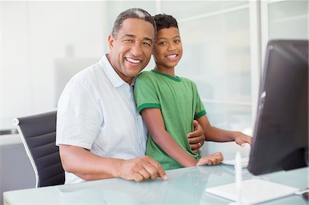 Portrait of smiling grandfather and grandson at computer Foto de stock - Sin royalties Premium, Código: 6113-07565564