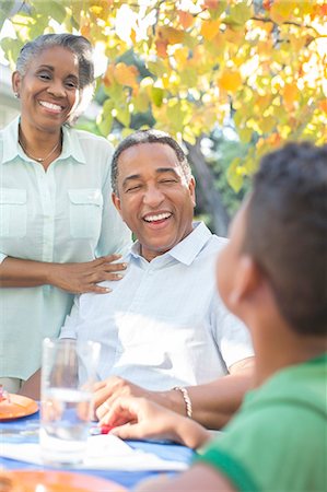 Grandparents and grandson laughing at patio table Photographie de stock - Premium Libres de Droits, Code: 6113-07565647