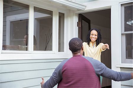 Enthusiastic woman greeting man in doorway Stock Photo - Premium Royalty-Free, Code: 6113-07565601