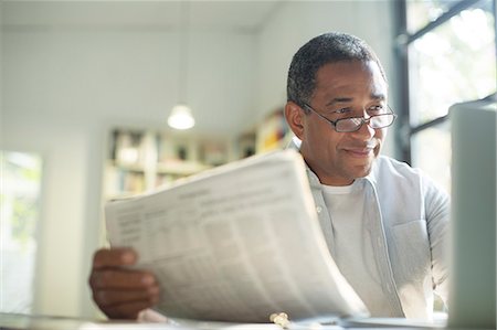 Senior man with newspaper using laptop Foto de stock - Sin royalties Premium, Código: 6113-07565608