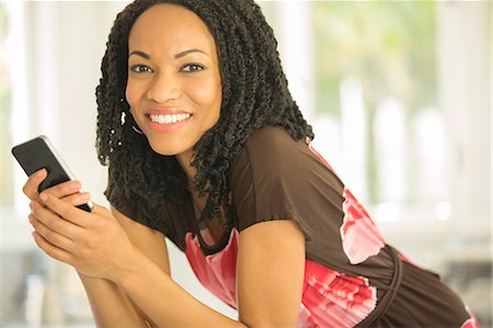 simsearch:6113-08321773,k - Close up portrait of smiling woman holding cell phone Stock Photo - Premium Royalty-Free, Code: 6113-07565626