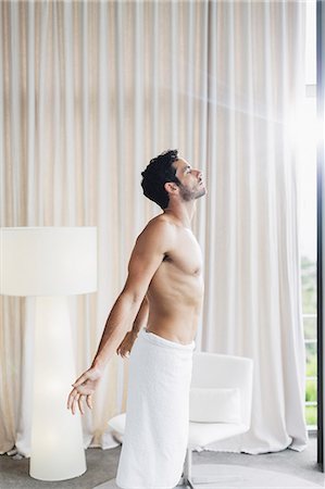 sunning - Man in towel basking in sunlight at bedroom window Stock Photo - Premium Royalty-Free, Code: 6113-07565729