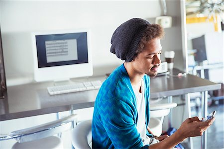 seated high view - Casual businessman text messaging with cell phone in office Stock Photo - Premium Royalty-Free, Code: 6113-07565859