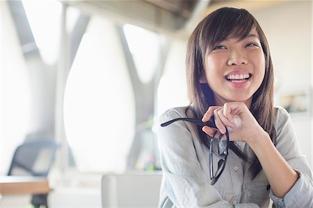 Businesswoman holding eyeglasses and laughing in office Stock Photo - Premium Royalty-Free, Code: 6113-07565863