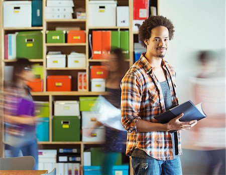 file - Portrait of casual businessman with co-workers rushing by in background Stock Photo - Premium Royalty-Free, Code: 6113-07565889