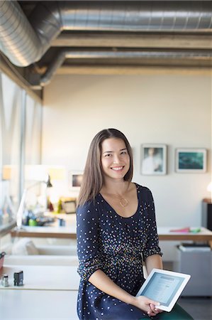 Portrait of smiling businesswoman with digital tablet in office Stock Photo - Premium Royalty-Free, Code: 6113-07565952