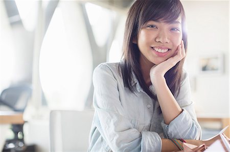 portrait of businesswoman - Portrait of smiling businesswoman with head in hands Stock Photo - Premium Royalty-Free, Code: 6113-07565931