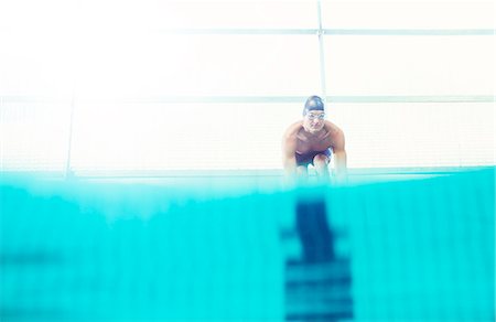 simsearch:6113-07588762,k - Swimmers poised on starting blocks Photographie de stock - Premium Libres de Droits, Code: 6113-07588676