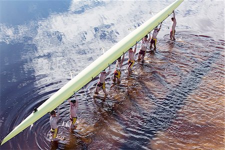 Rowing crew carrying scull overhead in lake Photographie de stock - Premium Libres de Droits, Code: 6113-07588749
