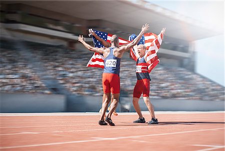 simsearch:6113-07588877,k - Runners celebrating and holding American flags on track Foto de stock - Sin royalties Premium, Código: 6113-07588750