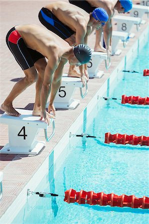 Swimmers poised at starting blocks Photographie de stock - Premium Libres de Droits, Code: 6113-07588754