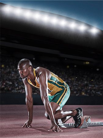 pic of a track and field start - Runner poised at starting block on track Stock Photo - Premium Royalty-Free, Code: 6113-07588769