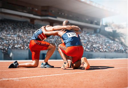 Runners huddled on track Stock Photo - Premium Royalty-Free, Code: 6113-07588788