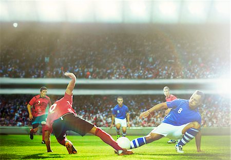 sports stadium flare - Soccer players kicking at ball on field Stock Photo - Premium Royalty-Free, Code: 6113-07588854