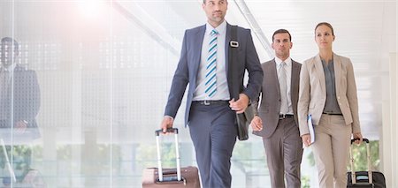 simsearch:6113-07588953,k - Business people pulling suitcases in corridor Foto de stock - Royalty Free Premium, Número: 6113-07588895