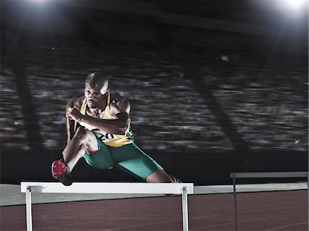 Runner jumping hurdle on track Photographie de stock - Premium Libres de Droits, Code: 6113-07588816