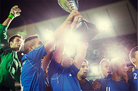 simsearch:6113-07310553,k - Soccer team celebrating with trophy on field Photographie de stock - Premium Libres de Droits, Code: 6113-07588838