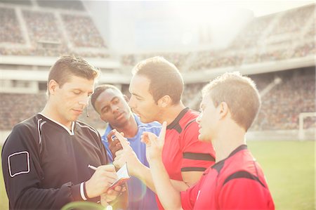 Soccer players arguing with referee on field Photographie de stock - Premium Libres de Droits, Code: 6113-07588839