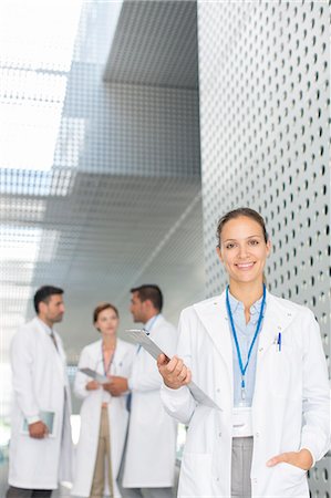 simsearch:6113-06498892,k - Portrait of confident doctor with clipboard in hospital corridor Stock Photo - Premium Royalty-Free, Code: 6113-07589050