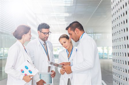 doctors reviewing medical records - Doctors with clipboard talking in hospital corridor Stock Photo - Premium Royalty-Free, Code: 6113-07589069