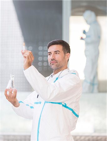 scrutiny - Scientist in clean suit examining liquid in test tube Stock Photo - Premium Royalty-Free, Code: 6113-07589035