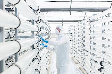 simsearch:6113-07589220,k - Engineer in clean suit examining pipes in laboratory Stock Photo - Premium Royalty-Free, Code: 6113-07589139