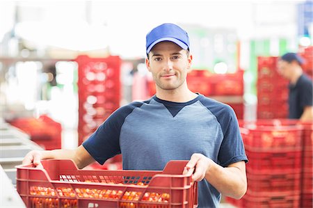 food factory worker - Portrait of confident worker holding crate of tomatoes in food processing plant Stock Photo - Premium Royalty-Free, Code: 6113-07589264