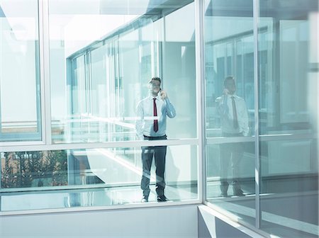 Businessman talking on cell phone in modern office Photographie de stock - Premium Libres de Droits, Code: 6113-07589275