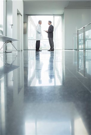 Doctor and administrator talking in hospital corridor Photographie de stock - Premium Libres de Droits, Code: 6113-07589276