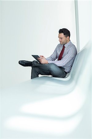 Businessman using digital tablet in lobby Foto de stock - Sin royalties Premium, Código: 6113-07589293