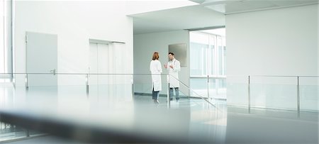 person in distance - Doctors talking in hospital corridor Stock Photo - Premium Royalty-Free, Code: 6113-07589296