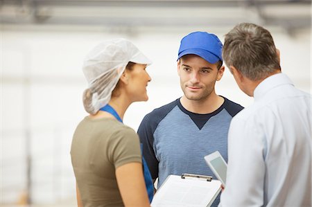 Supervisor and workers talking in food processing plant Stock Photo - Premium Royalty-Free, Code: 6113-07589298