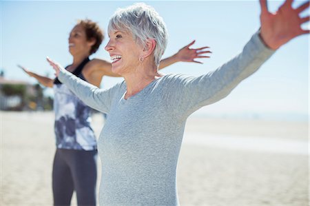 senior citizen outside copy space - Senior women stretching arms on beach Stock Photo - Premium Royalty-Free, Code: 6113-07589370