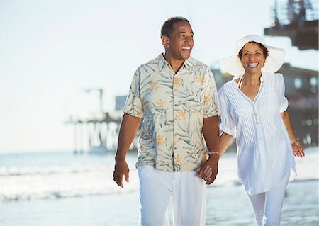retired couple - Couple holding hands and walking on beach Stock Photo - Premium Royalty-Free, Code: 6113-07589328