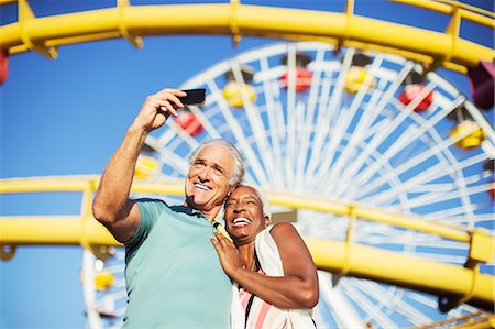 Senior couple taking selfie at amusement park Photographie de stock - Premium Libres de Droits, Code: 6113-07589338