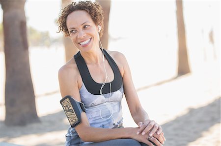 Smiling woman in sportswear wearing arm band Stock Photo - Premium Royalty-Free, Code: 6113-07589464