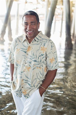 Portrait of confident senior man under pier at beach Foto de stock - Sin royalties Premium, Código: 6113-07589475